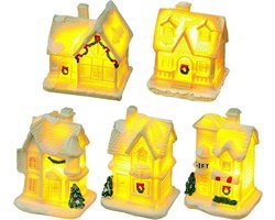 Verlichte kerststad met miniatuur huizen en decoratie voor binnen